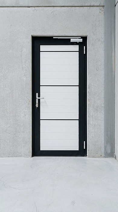 Portillon de service à cadre noir et panneaux vitrés installé à l'intérieur