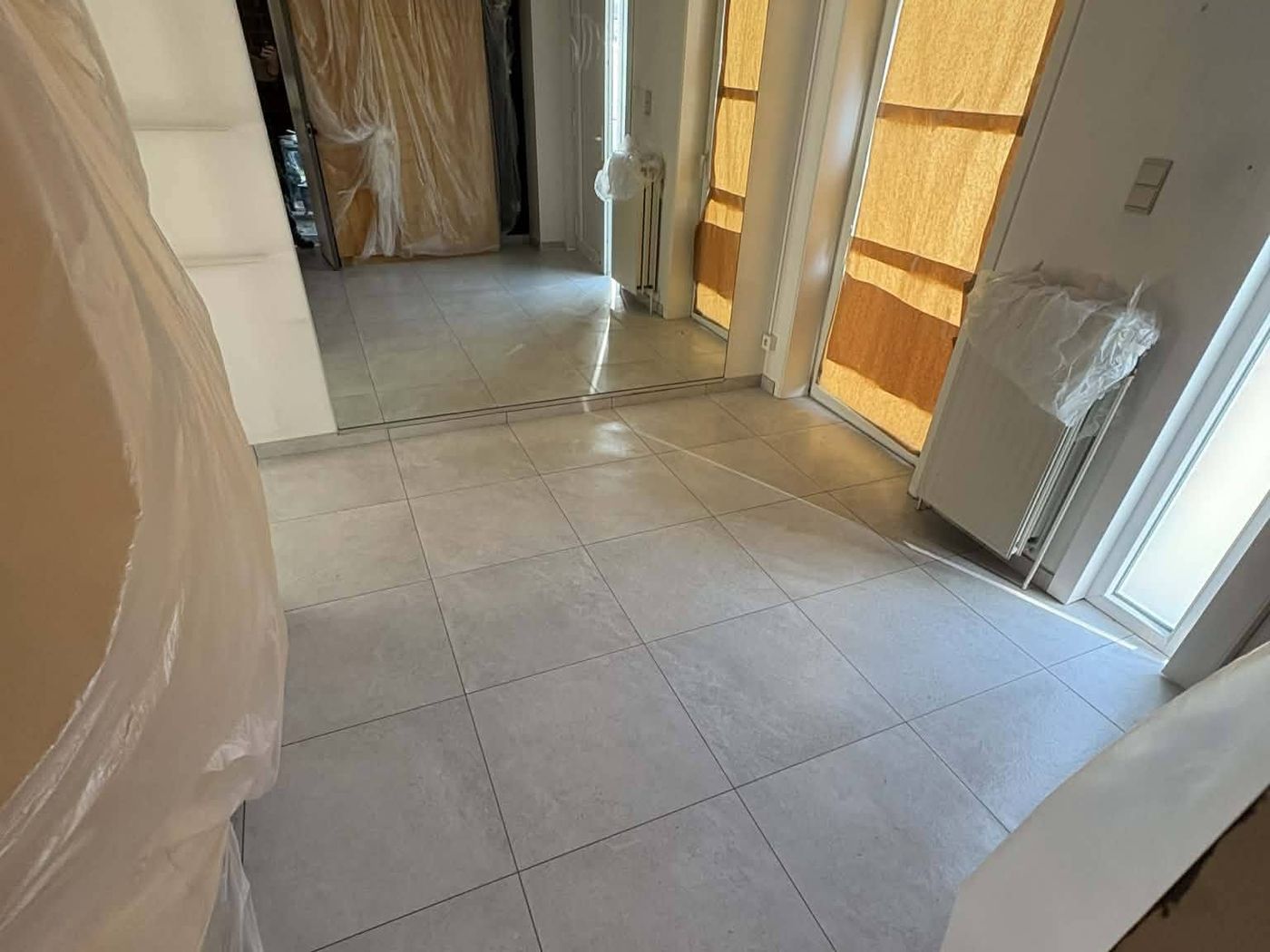 Carrelage grand format posé au sol dans une pièce claire à Manage