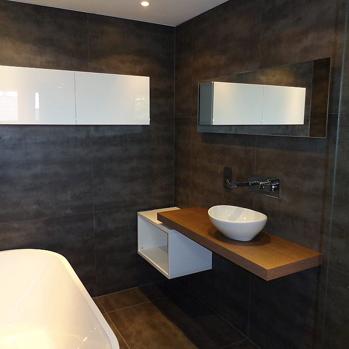 Salle de bain rénovée avec baignoire îlot et meuble vasque en bois sur mesure